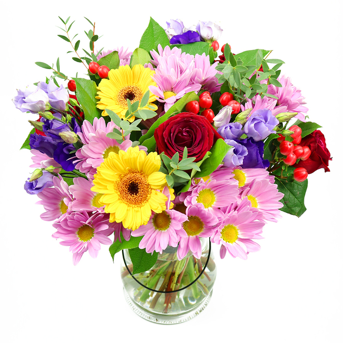 A lavish, colour-rich bouquet is arranged in a classic clear glass vase, positioned against a stark white background so that every flower appears crisp and luminous. In the centre, deep red roses take pride of place, their velvety petals layered tightly, suggesting affection and timeless romance. Just beside them, two golden yellow gerbera daisies with dark brown-orange centres stand like cheerful emblems of sunshine, immediately lifting the mood of the composition. Surrounding this bold heart, soft pink daisies and chrysanthemums spread out, their many fine petals and neat yellow centres offering a gentler, more playful touch. Woven throughout are purple and lavender lisianthus blooms, their bell-like forms and slightly frilled edges lending the bouquet a graceful, contemporary elegance. Small clusters of bright red hypericum berries appear here and there, adding rounded shapes and a glossy finish that contrasts beautifully with the softer petals. The entire arrangement is wrapped in a variety of green foliage, from broad, deep green leaves to lighter, more delicate sprigs, creating an impression of natural abundance reminiscent of Millbank's riverside plantings and the nearby gardens around Westminster. Through the clear glass vase, the stems can be seen carefully trimmed and splayed in clear water, a subtle reminder of the florist's meticulous care and attention to detail. The lighting is soft and even, with no distractions, allowing the bouquet's vibrant palette to set a mood of warm celebration. It feels perfectly suited for marking milestones, sending a heartfelt thank-you, or serving as a welcoming focal point on a dining or coffee table in a Millbank home or office.