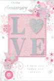 The card in this image is a tender celebration of enduring romance, blending soft pastel pinks and silvery greys much like a refined bouquet chosen for an anniversary dinner near the quiet streets of Millbank. At the heart of the design, the word LOVE is spelled out in soft, raised glitter letters that have a velvety shimmer. The letter O is replaced by a shining heart, filled with denser silver glitter that glows against the surrounding blush tones, becoming the visual centre of the composition. These raised elements sit on a gently tinted pink panel, subtly set apart from the rest of the card to frame the sentiment with warmth. Flowing out from this central word, delicate illustrated blooms in blush, mauve, and pale rose tones open with an almost watercolour softness. Their fine, flowing lines and translucent shading evoke the lightness and care of an English spring garden, not unlike the floral scenes you might glimpse in nearby riverside plantings. Slender vines and filigree curls intertwine with small leaves and petals, while tiny butterfly silhouettes and soft swirls add a sense of motion and whimsy. The background is a smooth, powdery pink, providing a calm, romantic field that allows the silver and pastel details to shine. Elegant script phrases-On Our Anniversary and I love you today and always-are positioned thoughtfully around the design, their curves echoing the flow of the botanical forms. The overall effect is intimate and heartfelt, a keepsake that visually captures the softness, depth, and shared history of a couple's journey together in the tranquil heart of Millbank.